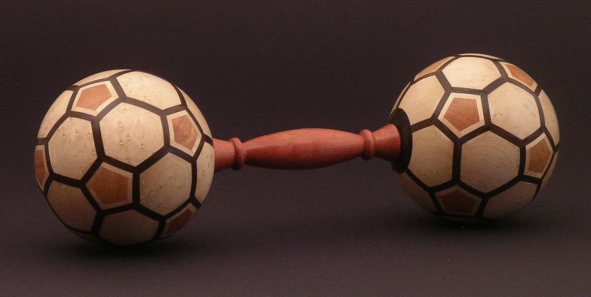 two patterned wooden balls on either end of a carved dowel