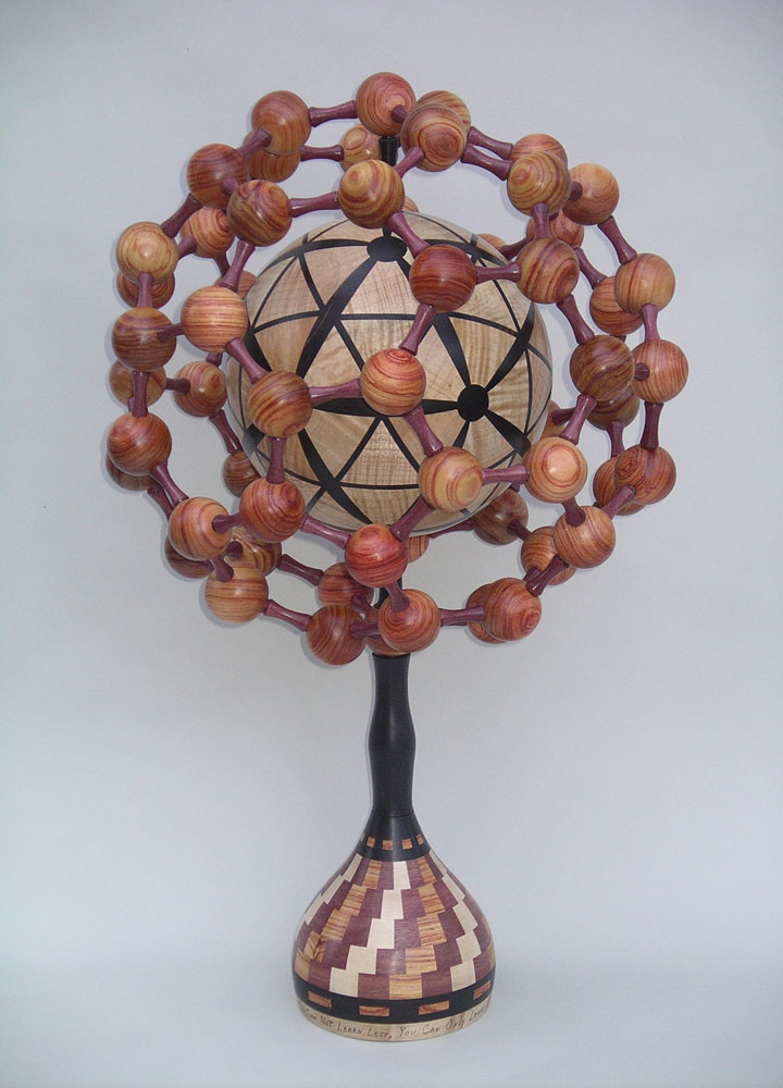 a tower of wooden beads surrounding a wooden globe