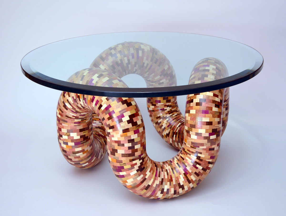 glass table with patterned wooden tube for legs