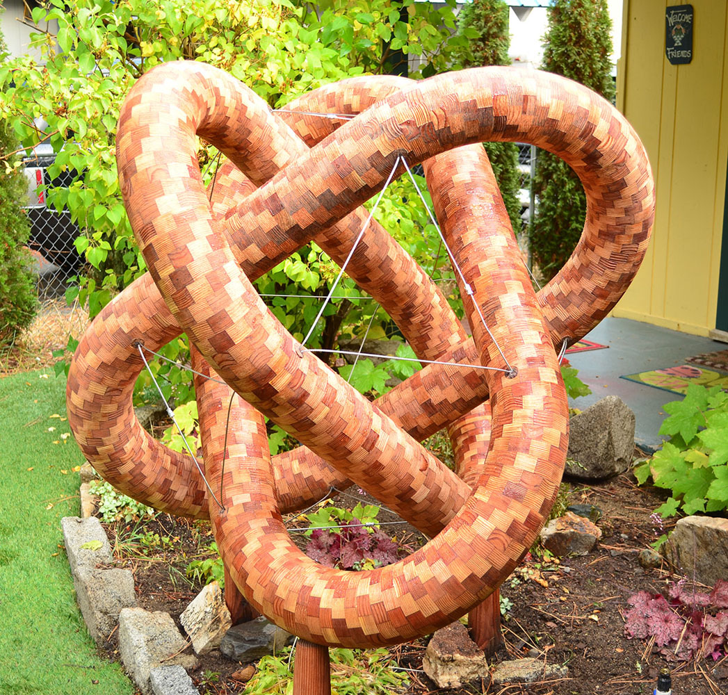 segmented wood turning sculpture outside in a yard
