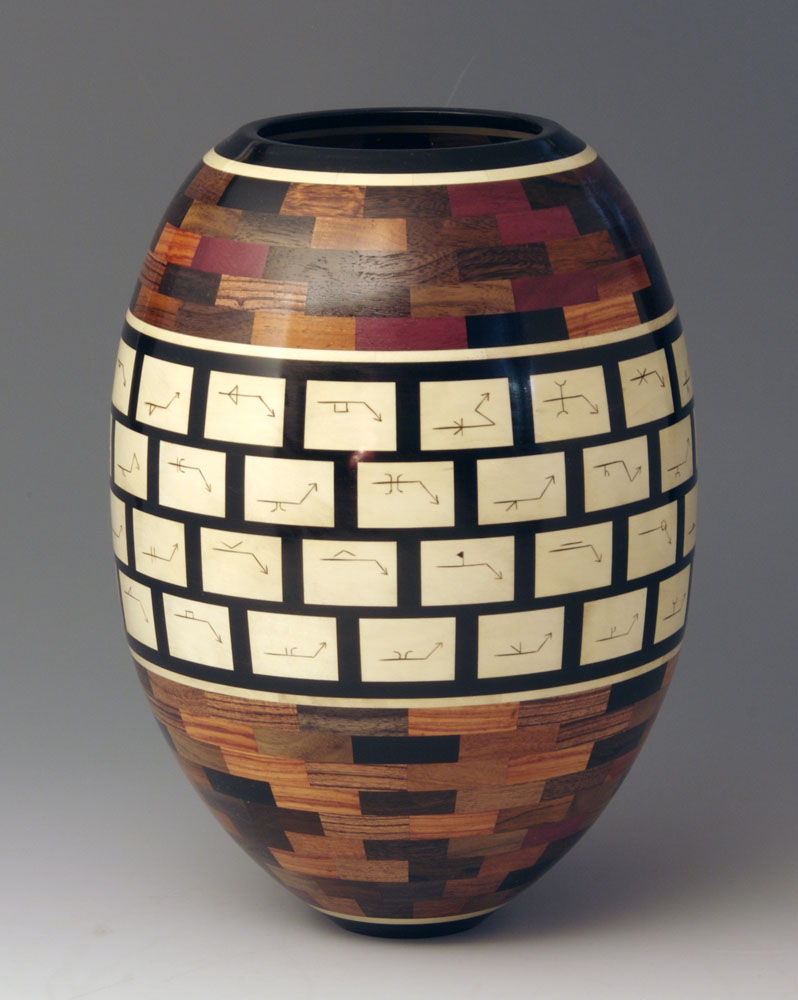 segmented wood turning vase with black and white pattern around the middle