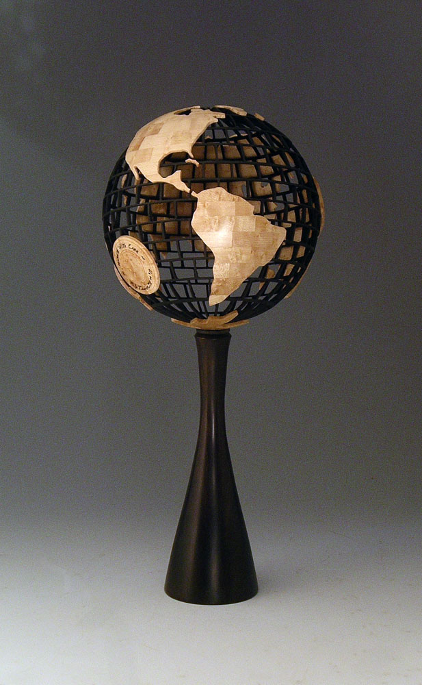 globe with wooden continents mounted on a black pedestal