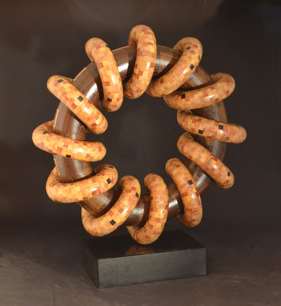 blond wooden rings wrapped around a larger brown wooden ring