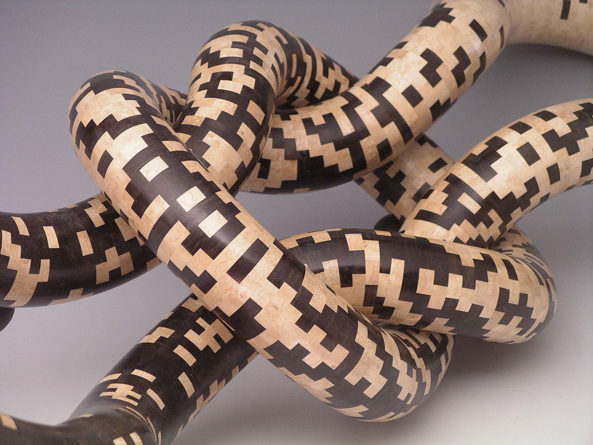 patterned segmented wood turning tubes tied in a knot