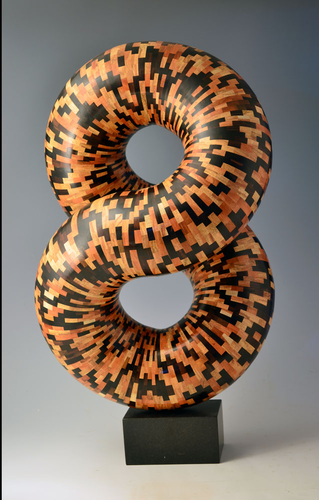 multicolored segmented wood turning tube twisted into a figure eight