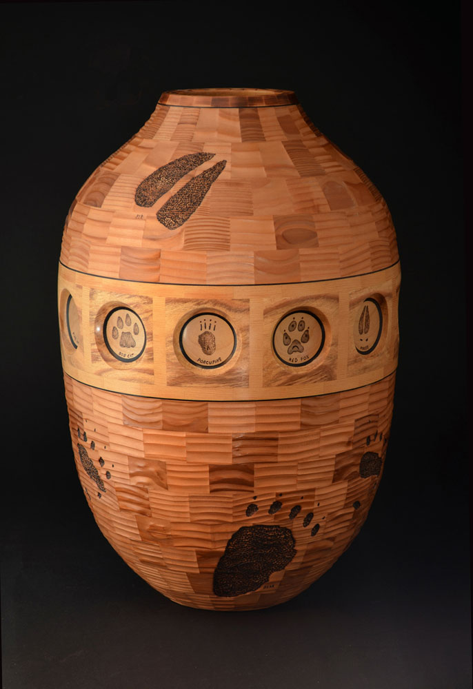 segmented wood turning vessel with bear paw carving