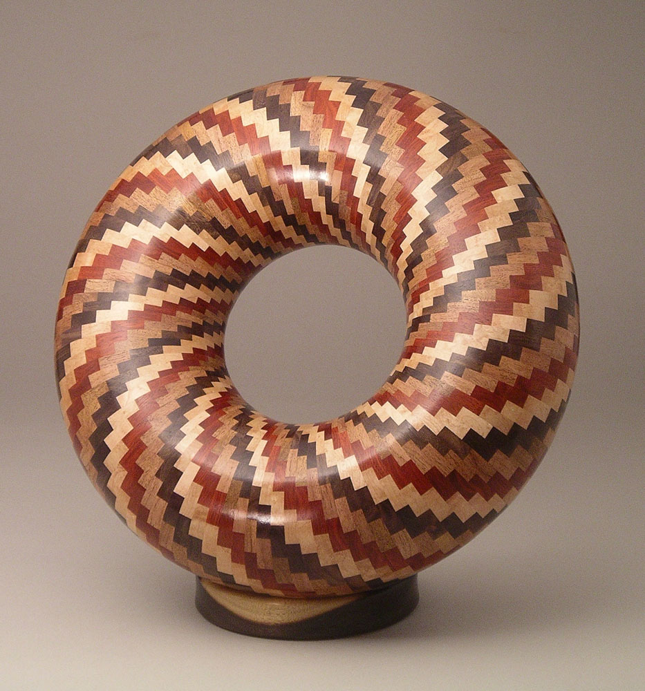 patterned segmented wood turning tube shaped into a circle